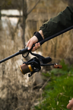 Hombre con ca&ntilde;a de pescar en la mano. Pescando carpas en el r&iacute;o.