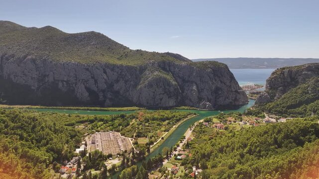 Drone aerial of Mila Gojsalic statue overlooking Omis, mountains and coastline.