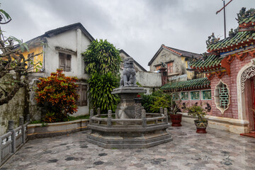 Obraz premium A stone lion statue sits atop a fountain in a courtyard in Hoi An, Vietnam. The statue is a popular tourist attraction and a symbol of the city's rich history.