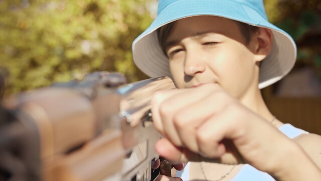Boy Playing with Toy Gun Outdoors in Summer, have fun and enjoy
