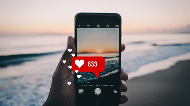 Mobile phone screen displaying social media heart notification counter with sunset beach background
