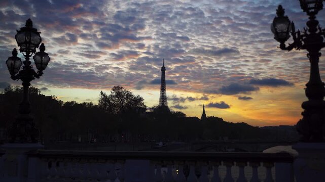 Paris Eiffel Tower in France at sunset seen from Bridge between lamps