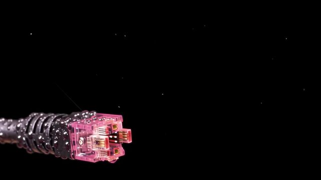 A network cable connector on a black background with pink glow.