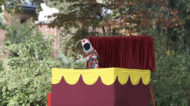 Puppet performance with clown character in outdoor puppet theater