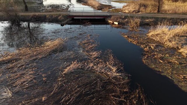 Low Altitude Forward Tilt Up Toward Wooden Bridge at Golden Hour