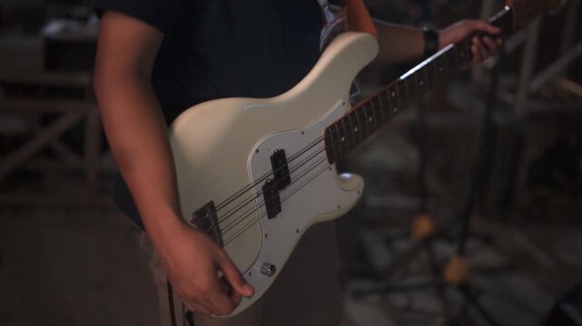 Close Up of Musician Playing White Electric Bass Guitar on Stage