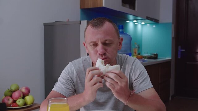 Man tastes traditional Vietnamese food for the first time, sits at home in the kitchen