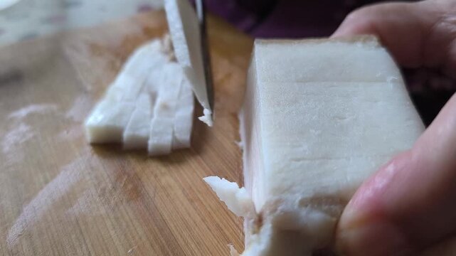 Cooking at home, pancetta - smoked bacon cut using sharp kitchen knife	
