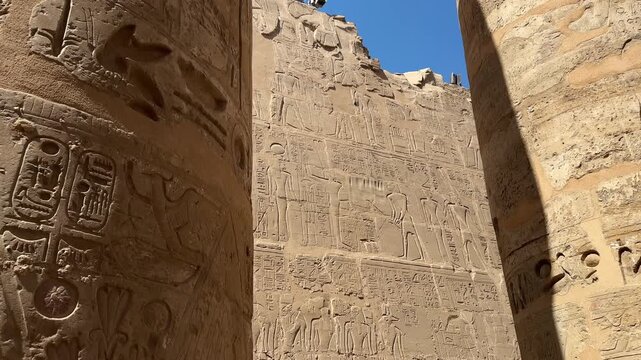Cinematic panning shot of ancient Egyptian wall reliefs in Karnak Temple, depicting ritual scenes, hieroglyphs, and a sacred barque