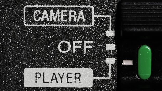 Close up of green camcorder mode switch moving from camera to player and back