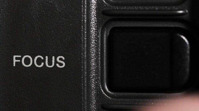 Macro close up of finger tapping focus control on camera body, suggesting mental clarity and attention