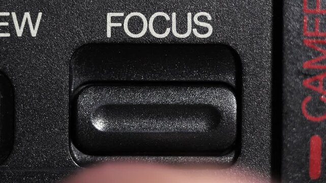 Close up of finger pressing focus button on camera, symbolizing concentration and clarity