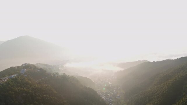 Aerial view revealing the hazy Pokhara city and Himalayan mountains in Nepal