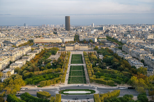 View from the Eiffel Tower overlooking Champ de Mars and &Eacute;cole Militaire in Paris, France, with the Montparnasse Tower rising above the Paris skyline in the distance.