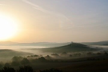 Obraz premium Autumn Sunrise over Misty Hills in the Province of Siena, Tuscany, Italy