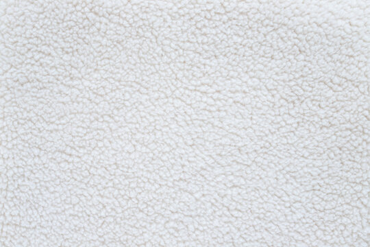 white fluffy sherpa fleece fabric texture background with soft wool material for winter clothing blankets or textile cozy mockup