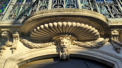 Mascaron beneath shell cornice on historic stone facade ©  Nicole & Mika Visua
