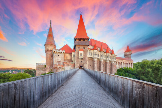 Breathtaking evening view of Hunyad Castle (Corvin's Castle) with wooden bridge at sunset .