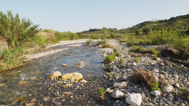 Small river with water flowing in decreasing quantities during drought