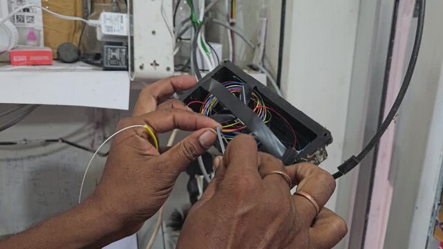 Close-up of a technician performing fiber optic fusion splicing using a precision machine to connect optical cables. The footage highlights high-speed internet infrastructure