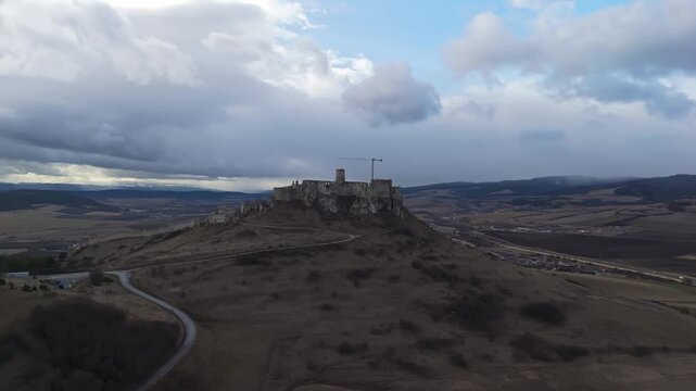 Spi&scaron; Castle, a medieval hilltop fortress with extensive stone ruins, dominates the rural landscape near Spi&scaron;sk&aacute; Nov&aacute; Ves and Žehra in eastern Slovakia in this wide panoramic drone view.