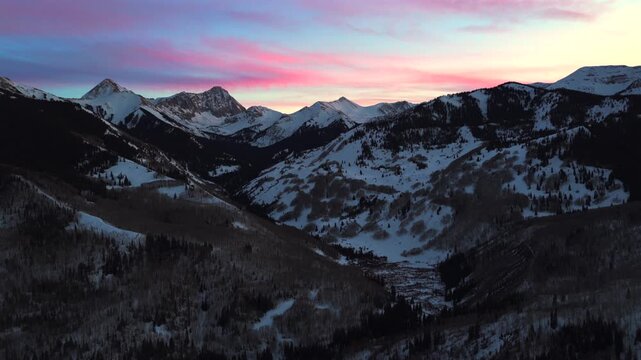 Alpenglow winter vibrant sunset golden blue hour Capitol Peak Wilderness 14er Aspen Snowmass aerial drone Colorado valleyElk Range Rocky Mountains Longs Peak Maroon Bells Pyramid Peak forward pan up