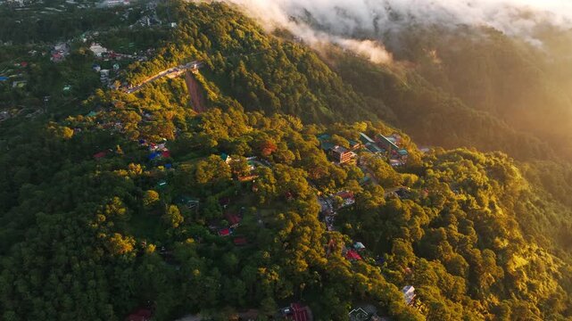 Sunrise glow spreads across forested hills, homes in Baguio Benguet, Philippines