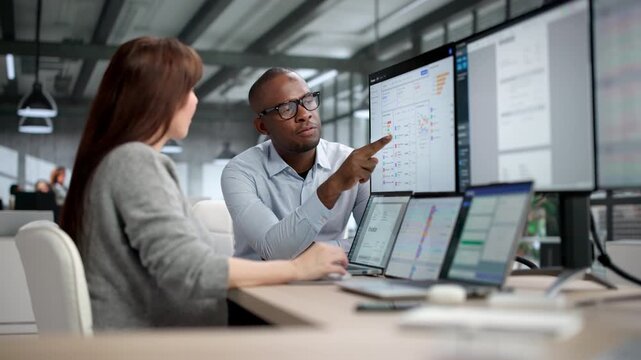 Two Auditors Collaborate In Office Analyzing Financial Data