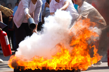 Employees firefighting training, Concept Employees hand using fire extinguisher fighting fire...
