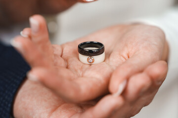 Fototapeta premium Couple exchanges wedding rings during ceremony in bright setting