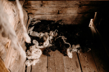 Raw wool and fleece inside rustic wooden interior. Natural material and traditional rural lifestyle concept.  © ShvedKristina