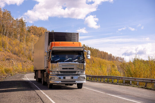 Japanese truck moving by a mountain road in autumn