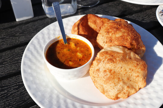 Indian cuisine Puri Bhaji. It is a traditional breakfast dish in North India. Puri is a deep fried bread made from whole wheat flour and Served with spicy Potato curry called bhaji or alu ki sabji.