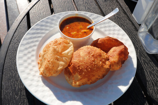 Indian cuisine Puri Bhaji. It is a traditional breakfast dish in North India. Puri is a deep fried bread made from whole wheat flour and Served with spicy Potato curry called bhaji or alu ki sabji.