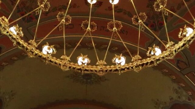 Cinematic POV tracking shot under ornate synagogue chandelier revealing sanctuary hall