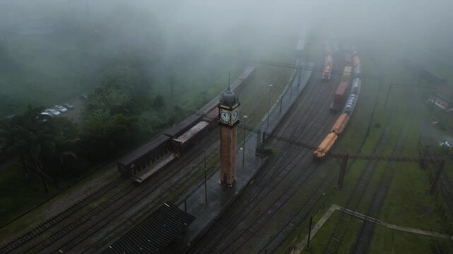 Atmospheric drone footage capturing misty morning fog enveloping historic railway station and vintage train cars in Paranapiacaba district, Santo Andr&eacute;, S&atilde;o Paulo, Brazil.