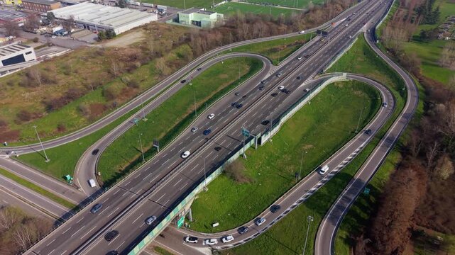 Aerial top view of major highway interchange on A50 Tangenziale Ovest Milan with flowing traffic.