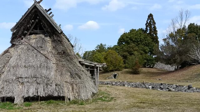 Traditional Jomon period thatched house in Japan, ancient dwelling exterior in rural landscape