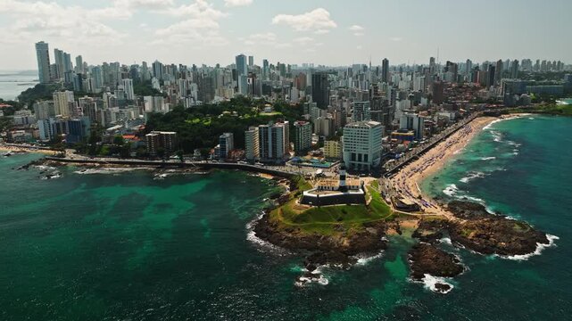 Aerial view of Salvador da Bahia cityscape, Barra Lighthouse, beach and azure sea. Tropical Travel Destination. Aerial landscape of Coastal City. Salvador, Bahia, Brazil.