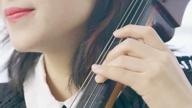 Serene classical music performance from violin fingerboard on musician cellist rehearsal of cello in concert hall music orchestral instrument string, focused on bow movement, musical expression