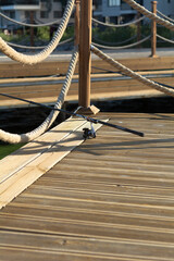 Naklejka premium A fishing rod on a wooden pier with a rope railing. Relaxation concept. Selective focus.