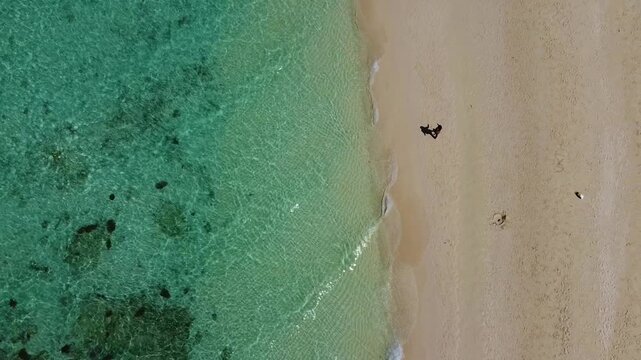 Aerial drone footage of Bamboo Island near Phi Phi Islands showing turquoise water, coral reefs, longtail boats and white sand beaches.