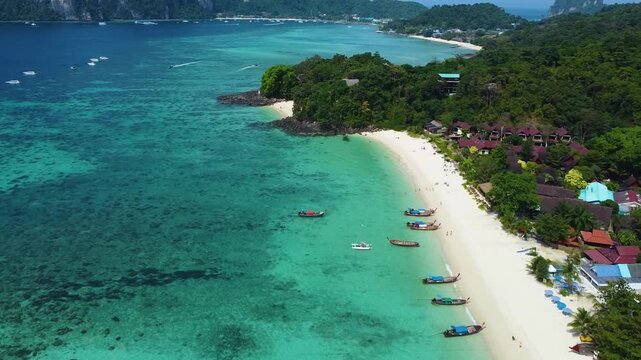 Drone aerial views of Phi Phi Island including Long Beach, turquoise waters, tropical coastline and traditional longtail boats.