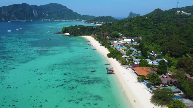 Drone aerial views of Phi Phi Island including Long Beach, turquoise waters, tropical coastline and traditional longtail boats.