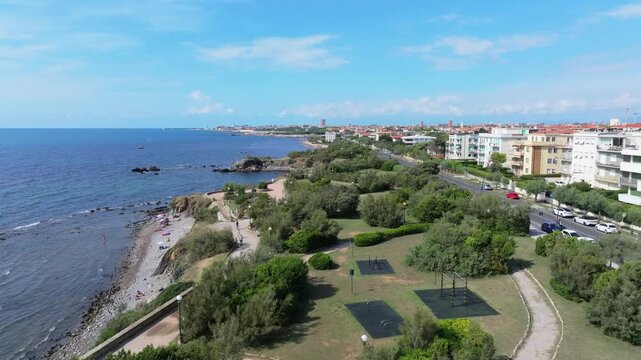 slow rising aerial from Liguarian Sea over city park of Parco Pubblico della Ballerina, Livorno, Italy