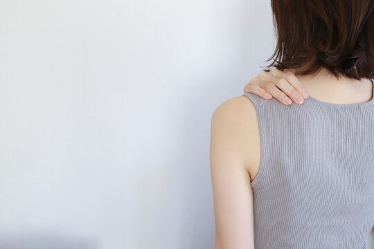 肩こりに悩む女性の後ろ姿