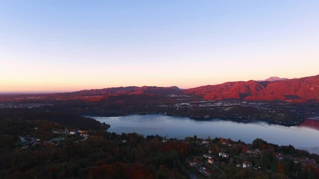 Lake Orta and Pella village at sunset, surrounded by mountains and autumn trees in Piedmont