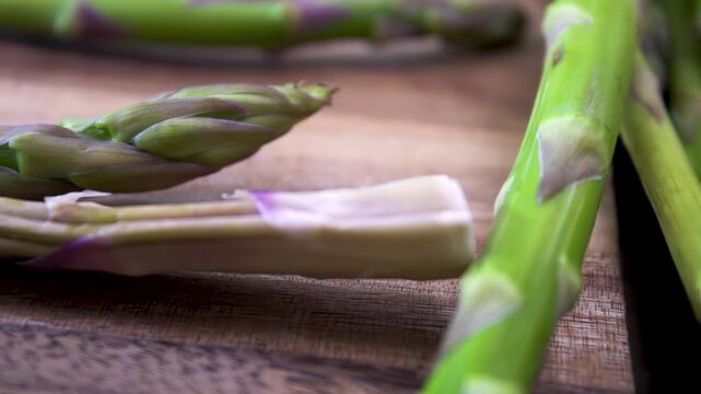 Fresh Green Asparagus (Asparagus officinalis) Spears on Wooden Surface, Macro Dolly Shot, Healthy Organic Food Concept, 4K 