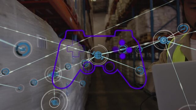 Animation of game controller, connected icons over asian worker scanning inventory in warehouse