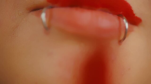 Woman messily applying red lipstick close up